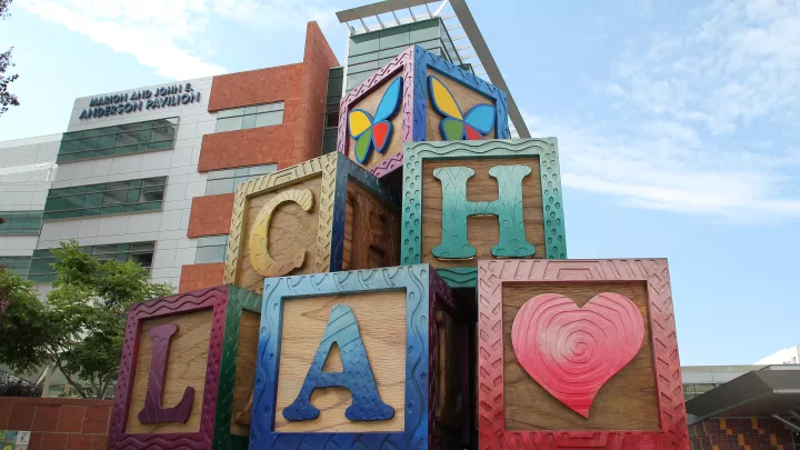 A large, colorful statue of children's toy blocks with the letters C-H-L-A on them, as well as a heart and butterfly logo.