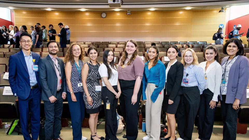 11 men and women stand and smile for the camera.