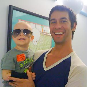 2-year-old Hunter wears his dad, Michael's, aviator sunglasses while Michael holds Hunter.