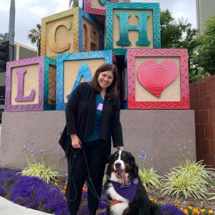 Kate and therapy dog Kacey in front of the CHLA blocks.