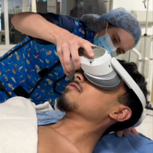 Hunt fits the VR goggles to a patient's head in pre-op.
